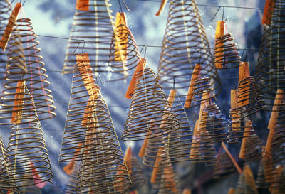 Low angle view of spiral incenses hanging at temple