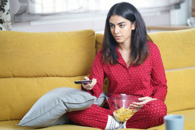 Young woman sitting on sofa at home