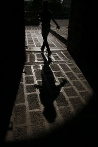 Rear view of silhouette woman walking on street