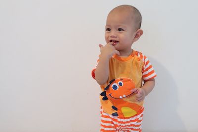 Cute boy looking away against white background