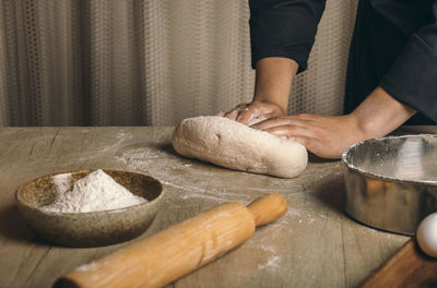 A woman kneads the dough with flour close-up. the cook prepares bread dough