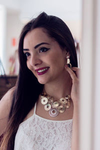 Close-up of young woman trying earring while standing in store