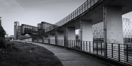 Bridge by buildings against sky in city