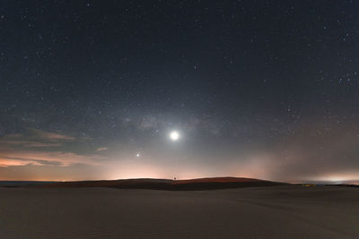 Scenic view of landscape against star field at night