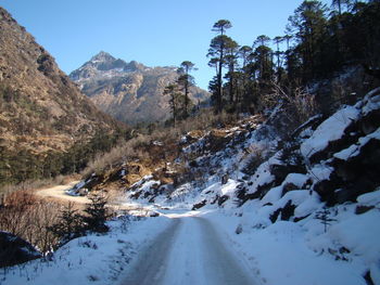 Road amidst snowcapped mountains against sky