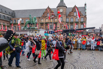 People walking on street against buildings in city