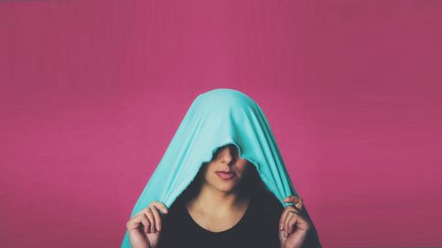 Portrait of a young woman over pink background