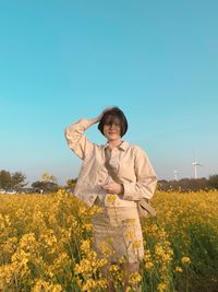 Full length of woman standing on field against clear sky