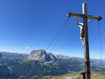 Cross on mountain against clear blue sky