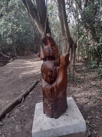 Statue amidst trees in forest