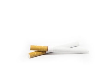 Close-up of cigarette smoking over white background