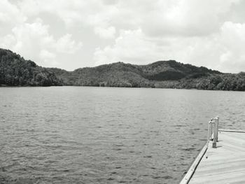 Scenic view of lake and mountains against cloudy sky