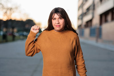 Portrait of mature woman gesturing while standing outdoors