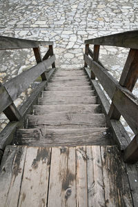 High angle view of empty wooden steps leading towards footpath