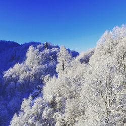 Low angle view of snow on mountain against blue sky