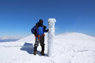 Full length of man standing on mt asama against clear blue sky during sunny day