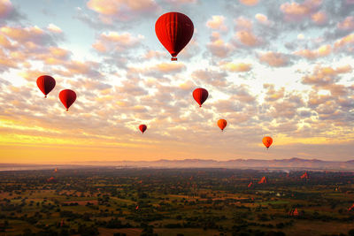 Hot air balloons flying against sky during sunset