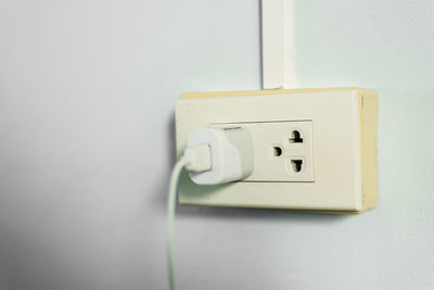 Close-up of electric outlet against wall