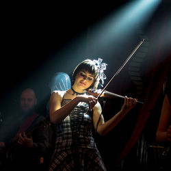 Female violinist playing violin in nightclub