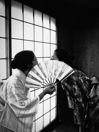 Japanese women holding folding fan at home