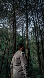 Rear view of men standing in forest