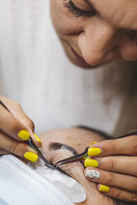 Close-up of woman hand holding yellow pen