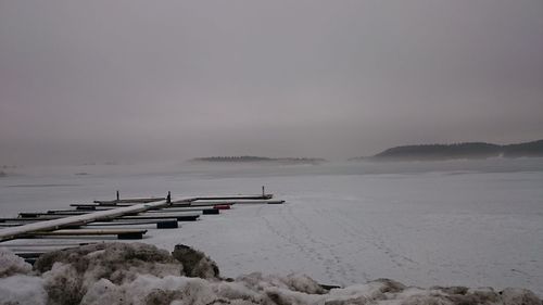 Scenic view of frozen lake against cloudy sky