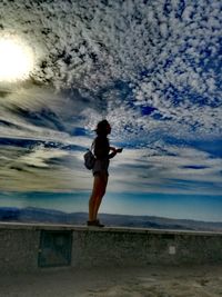 Full length of woman standing on beach against sky