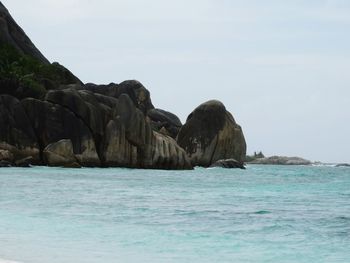 Rock formation in sea against sky