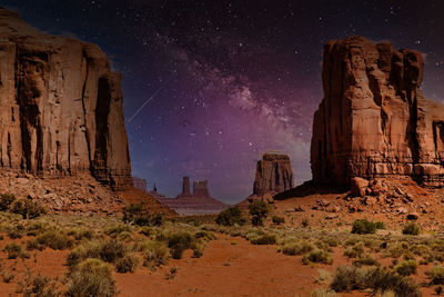 Rock formations on landscape against sky at night