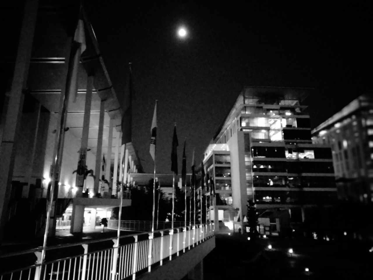 ILLUMINATED STREET AMIDST BUILDINGS IN CITY