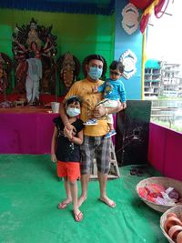 Full length of friends standing against wall