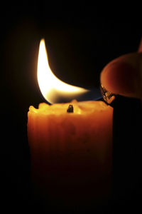 Close-up of lit candle in the dark