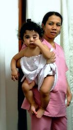 Portrait of friends standing against wall