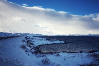 Snow covered land against sky