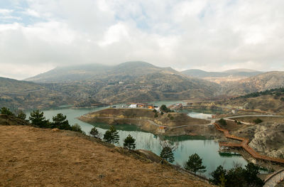 Scenic view of river and mountains against sky