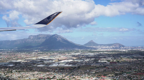 Airplane flying over landscape against sky