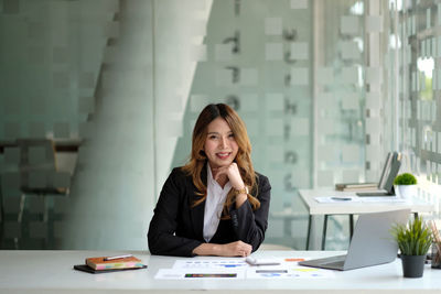 Businesswoman using mobile phone while sitting in office