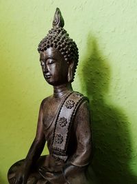 Statue of buddha against wall