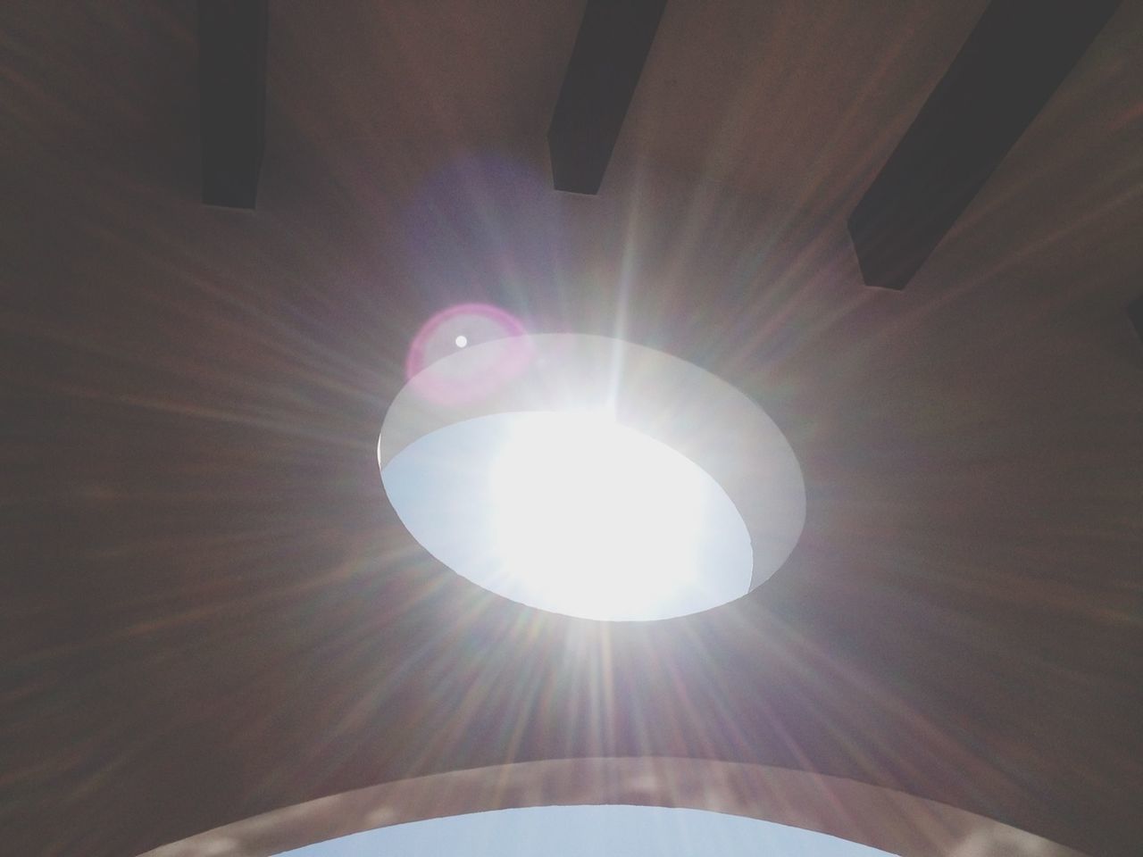 low angle view, sun, indoors, lens flare, sunbeam, ceiling, sunlight, lighting equipment, glowing, bright, built structure, directly below, electricity, no people, shiny, architecture, close-up, pattern, illuminated, light bulb