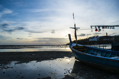 Boats in calm sea against cloudy sky