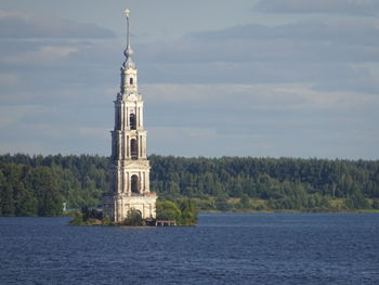 View of tower by building against sky