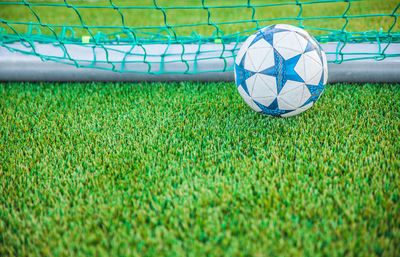 Soccer ball by net on field