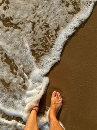 Low section of man relaxing on beach