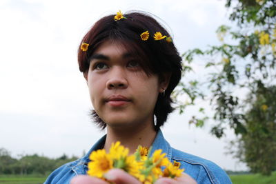 Close-up of woman holding yellow flowers