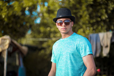 Portrait of young man wearing sunglasses standing outdoors