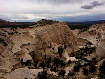 Scenic view of desert against cloudy sky