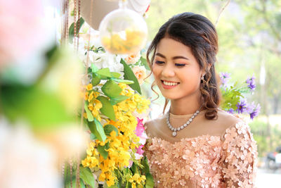 Portrait of smiling young woman against plants