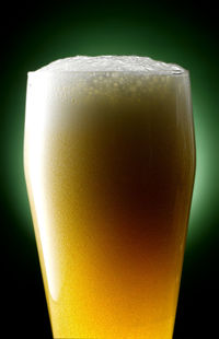 Close-up of beer glass against black background