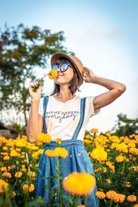 Woman standing amidst flowering plants on field